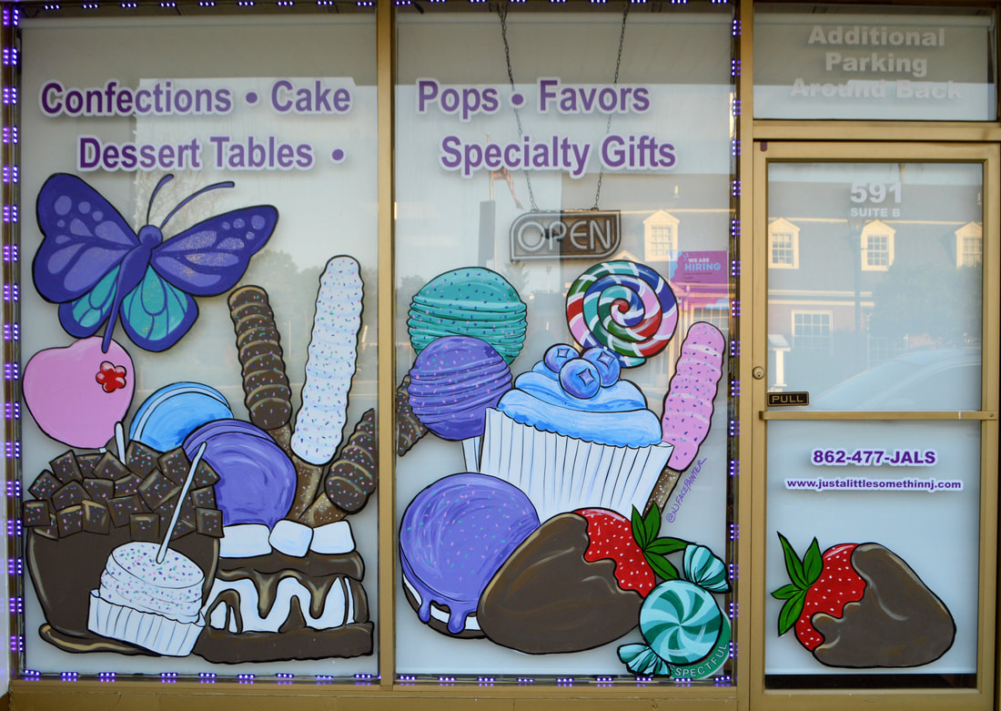 Product Window Art at Just a Little Somethin' Chocolate & Sweets Boutique in Pompton Plains, Morris County, NJ featuring a cupcake, chocolate covered pretzels, cake pops, a lollipop, a s'more, a chocolate apple, and candy