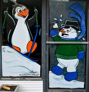 Winter Window Art Featuring a Penguin Skiing into a Snowman, in Newton, Sussex County, NJ