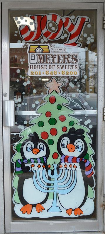 Christmas & Chanukah Door Painting at Meyer's House of Sweets in Wyckoff, Bergen County, NJ featuring penguins in front of a Christmas tree lighting a menorah